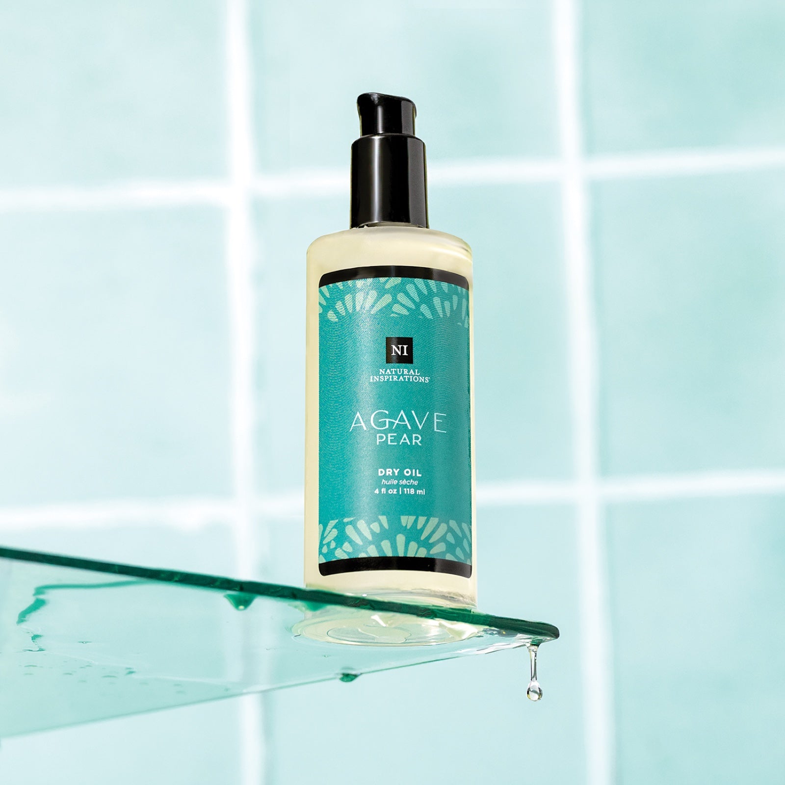 view of agave pear dry oil on a glass surface with blue tile in the background