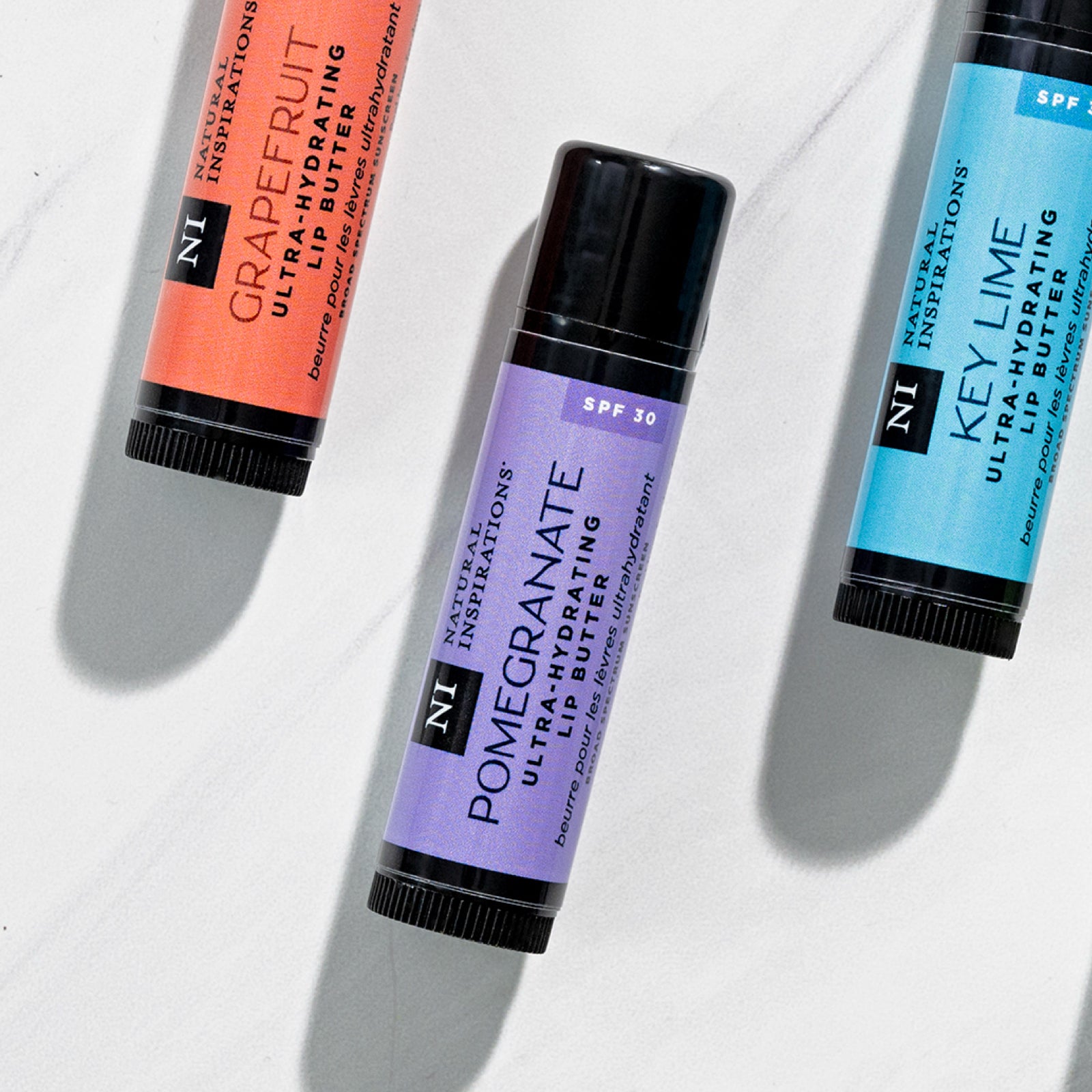 overhead view of lip butter with Pomegranate flavor in focus