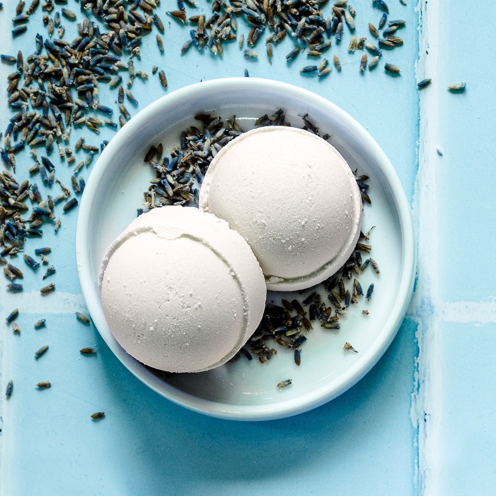 overhead view of shower steamers in a dish on a blue tile background