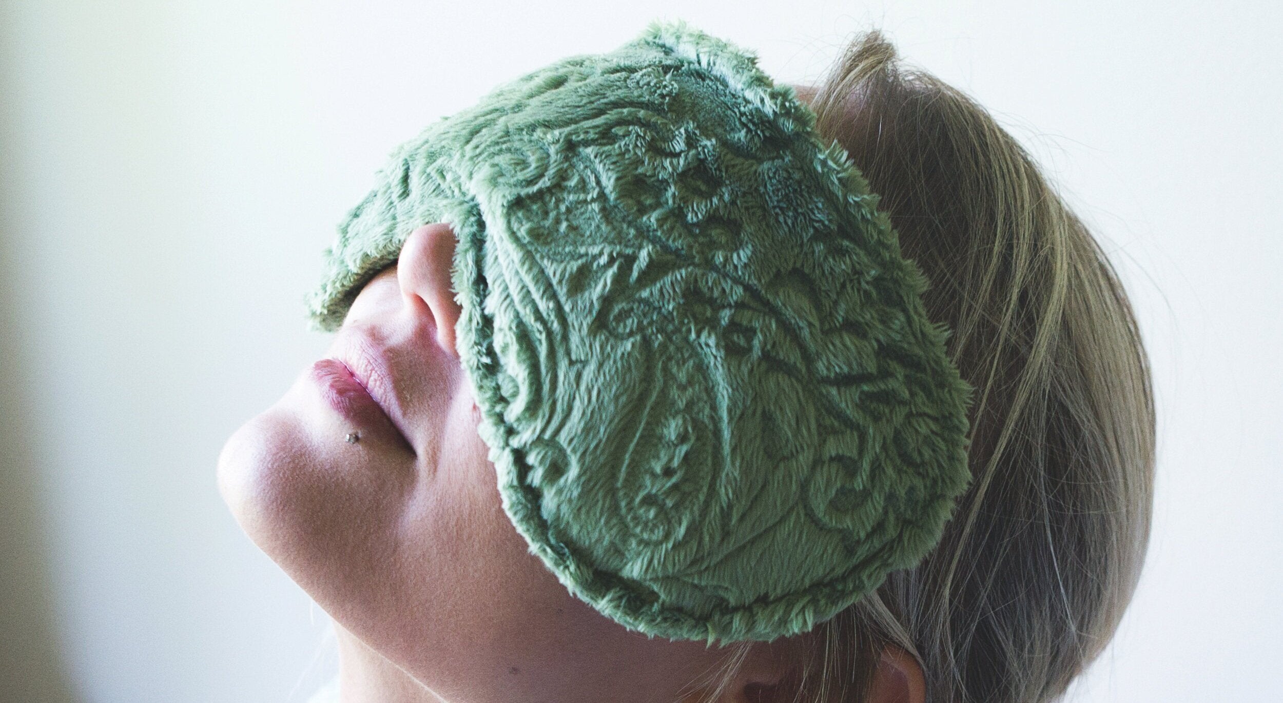 woman with a relaxing eye pillow resting over her face
