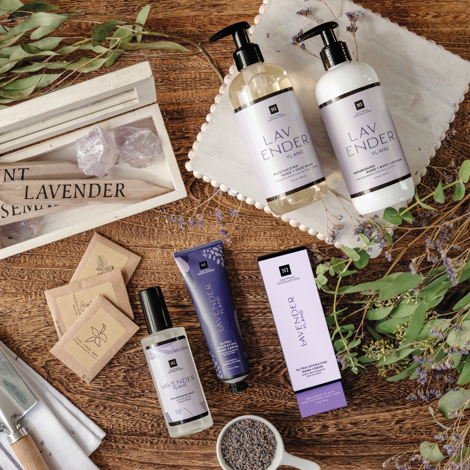 overhead view of lavender ylang products on a table with gardening tools and dried plants