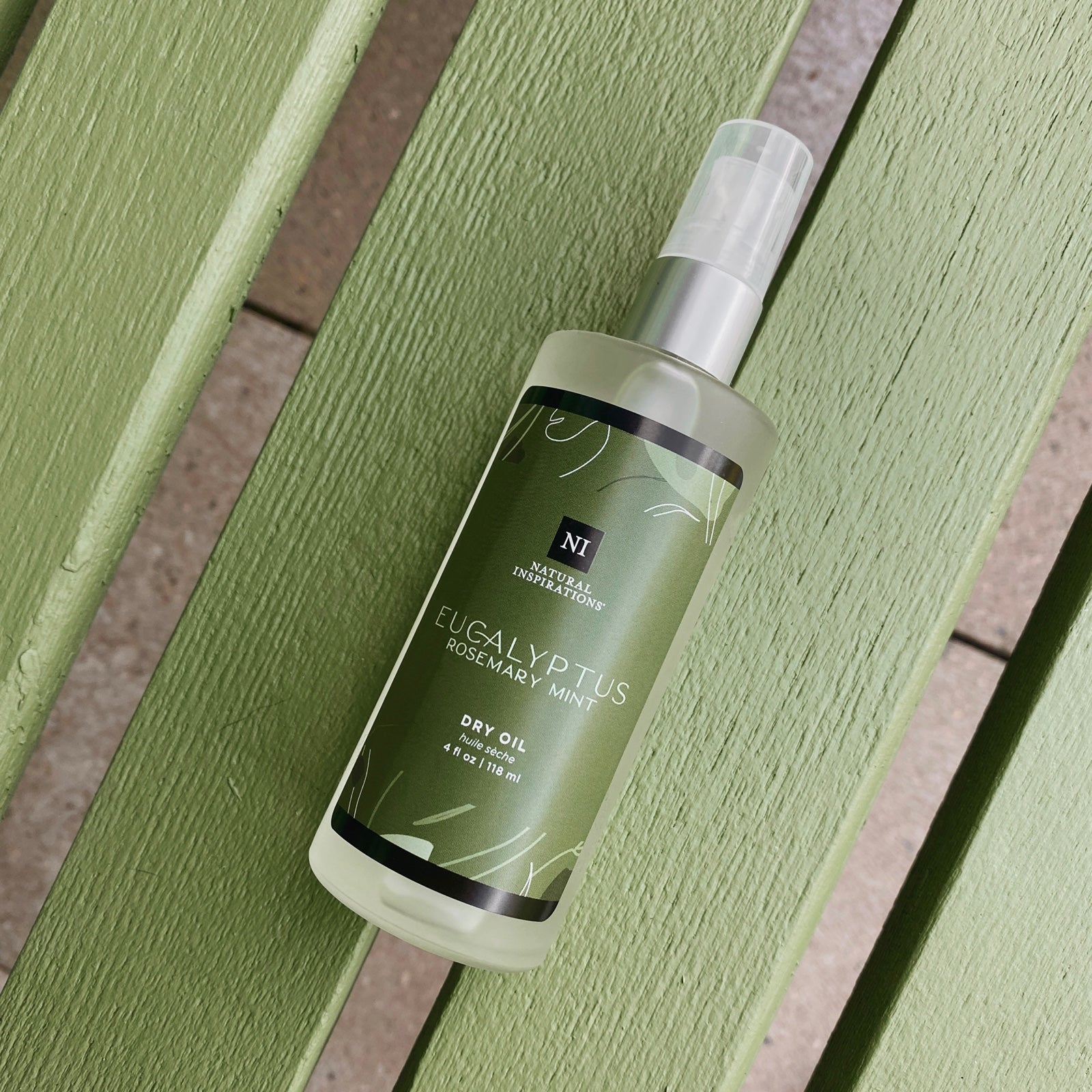 overhead view of eucalyptus rosemary mint dry oil on a green wooden bench