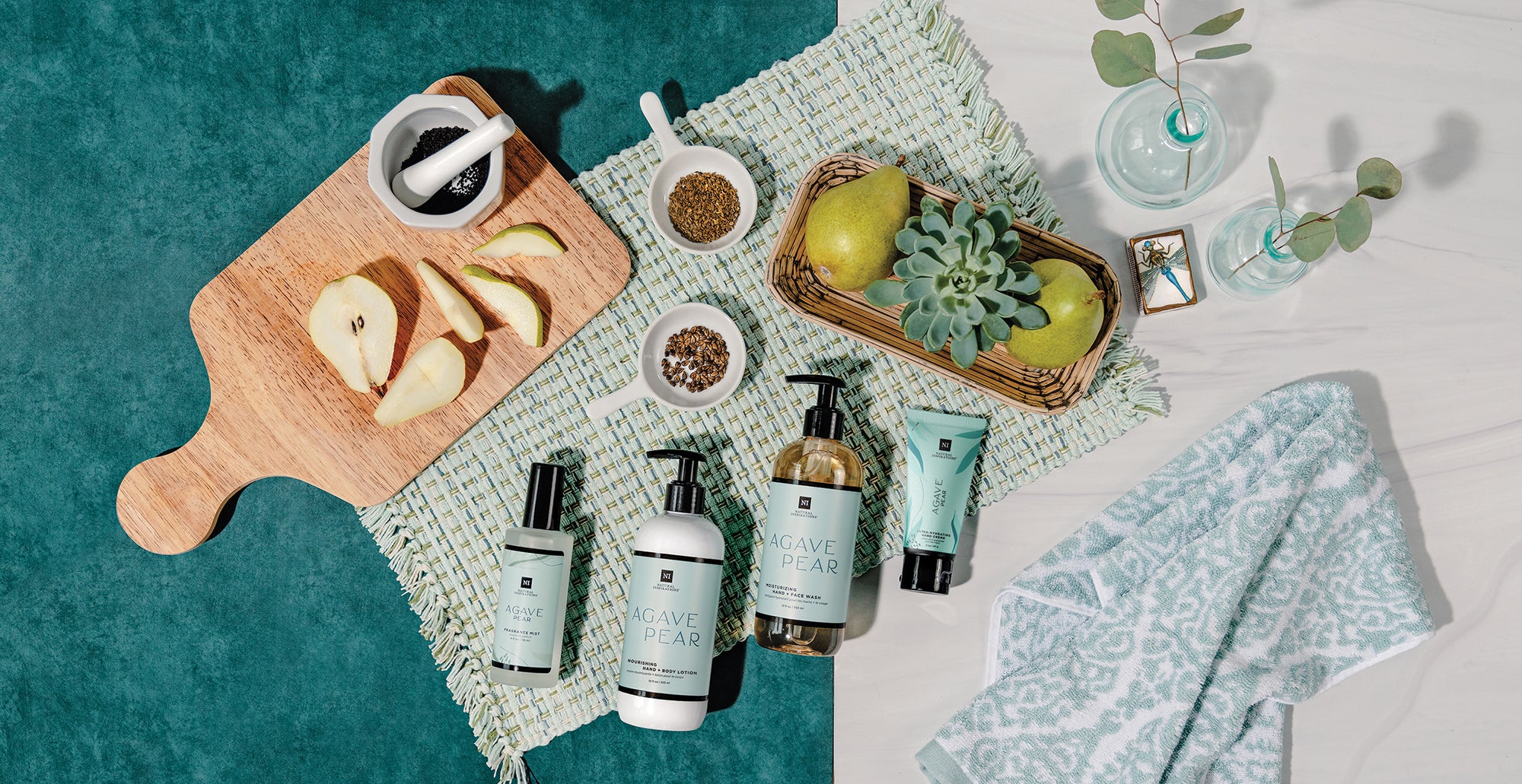 overhead view of agave pear fragrance mist, hand lotion, hand wash and mini hand cream in a beautiful tabletop setting with exseed ingredients, and pears