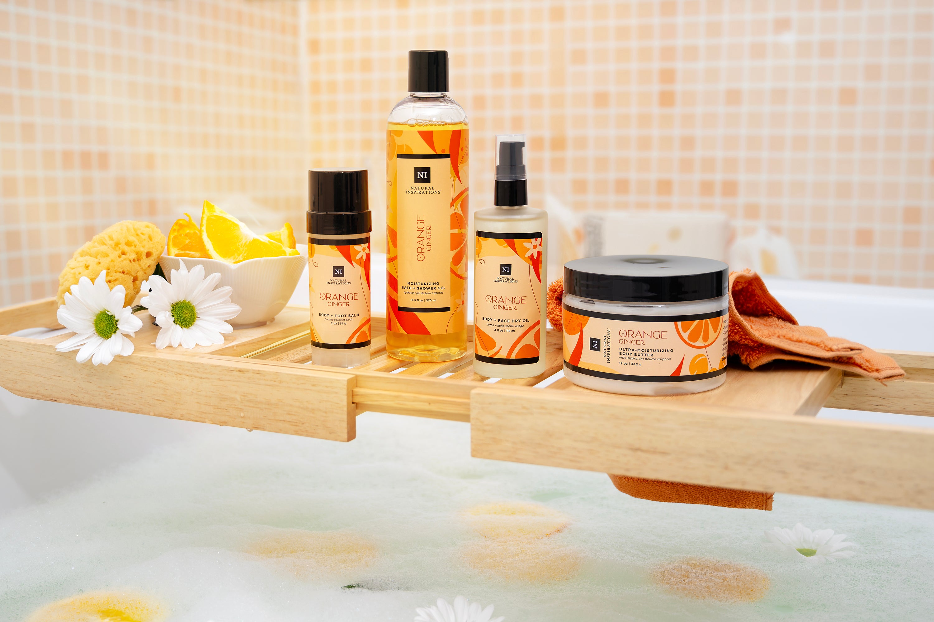 Bath products including bottles and jars on a wooden tray over a bathtub with flowers and lemons.